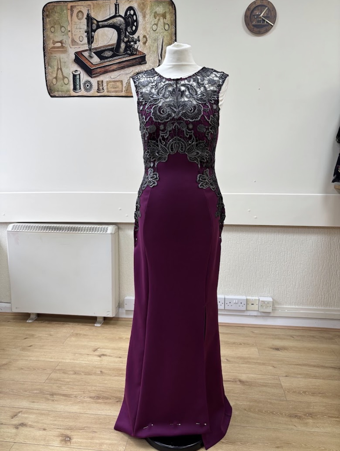Deep plum occasion dress with ornate lace on a mannequin