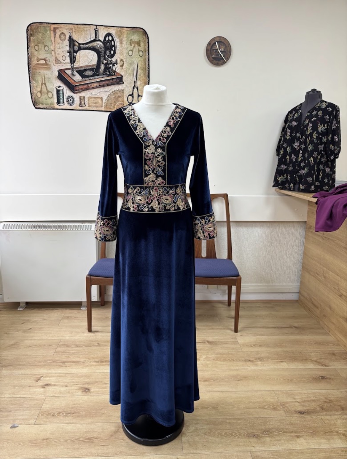 Navy embroidered occasion dress displayed on a mannequin