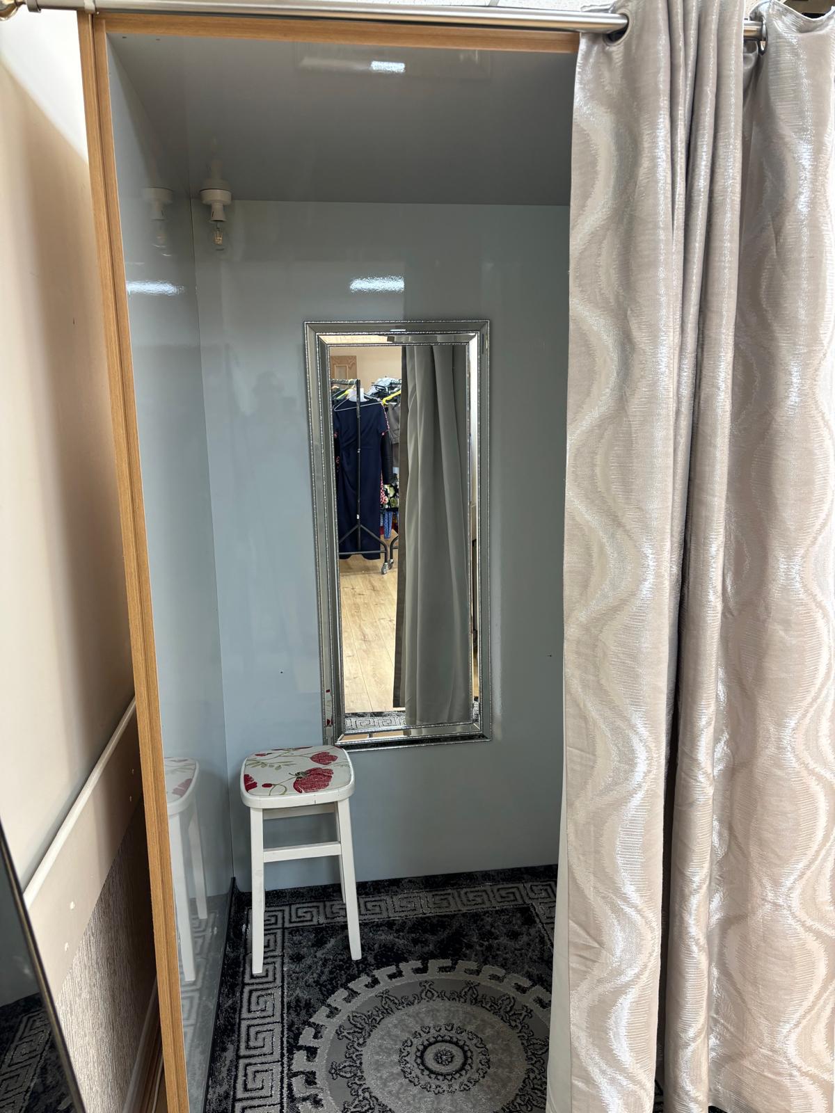 Mirror, stool and curtain inside the Stitch & Sew fitting room