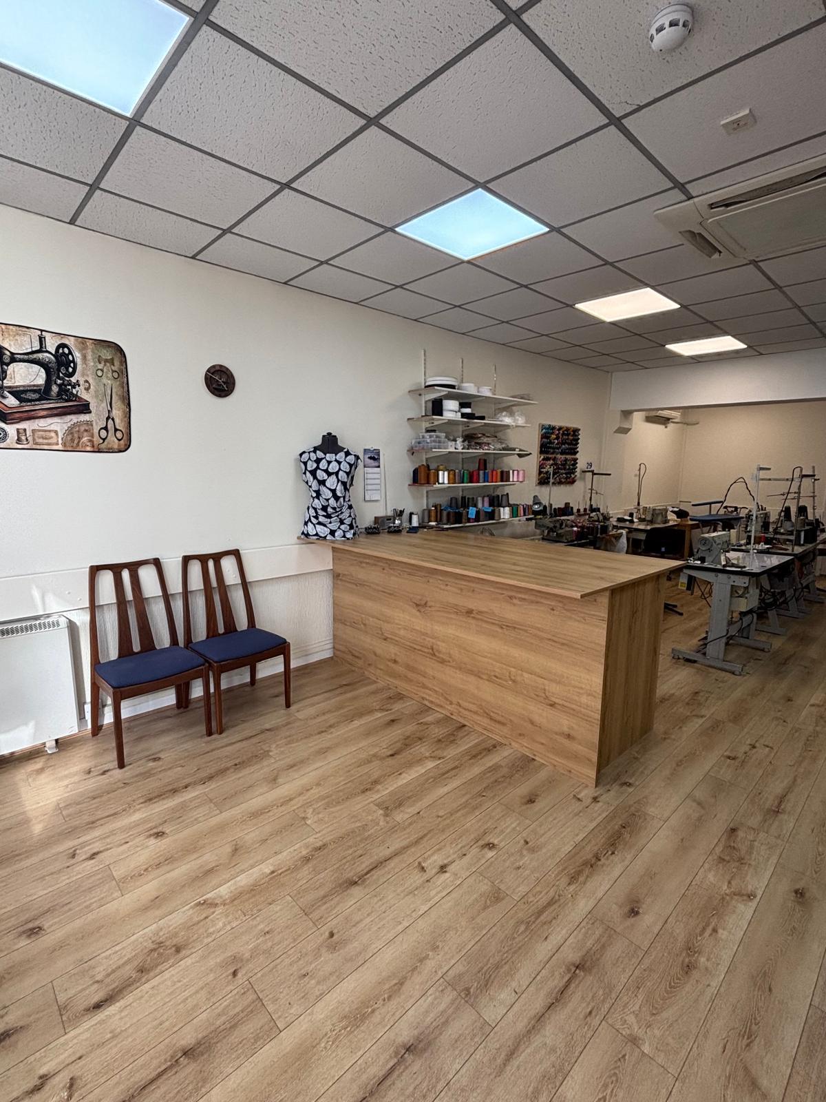 Wooden customer counter and tailoring workspace inside Stitch & Sew