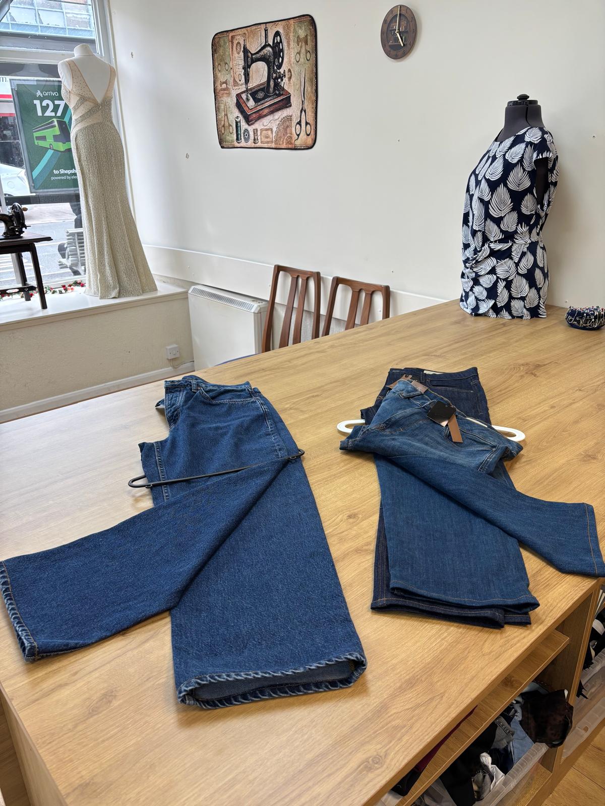 Jeans laid out on the Stitch & Sew worktable for alteration