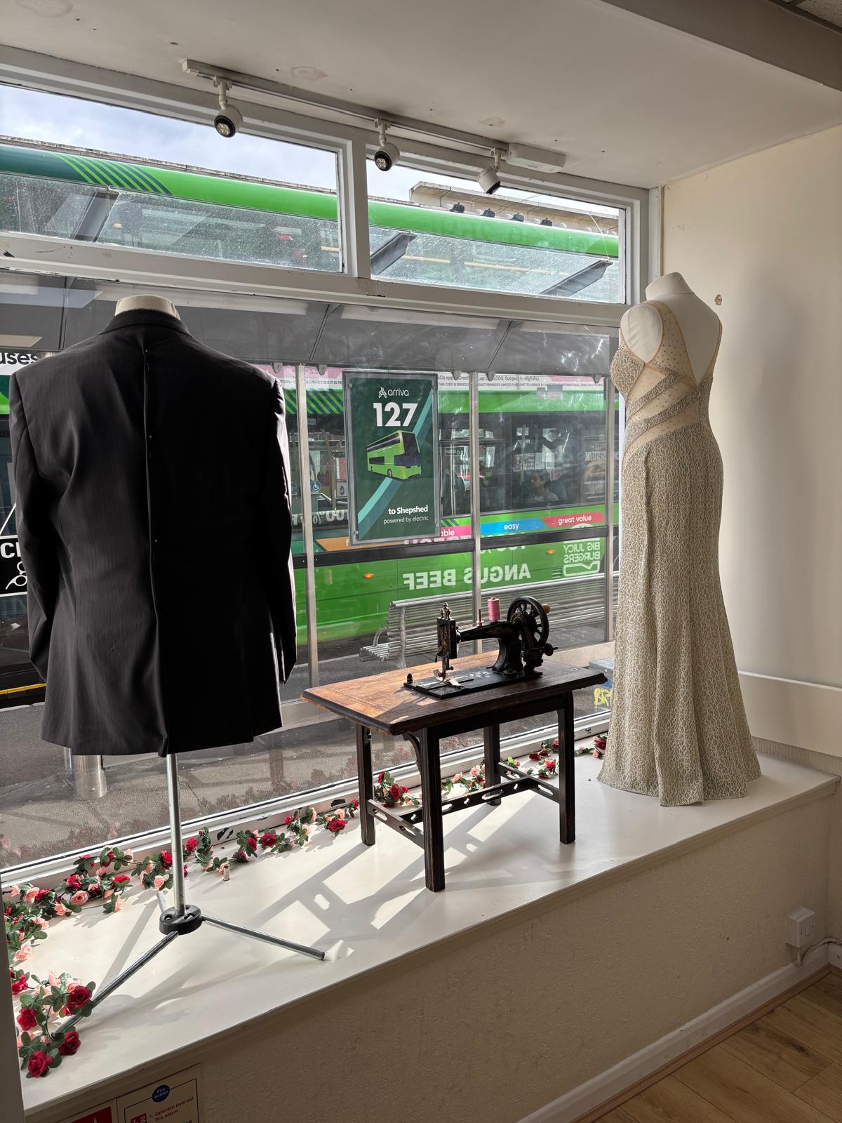 Suit, occasion dress and vintage sewing machine in the Stitch & Sew window display